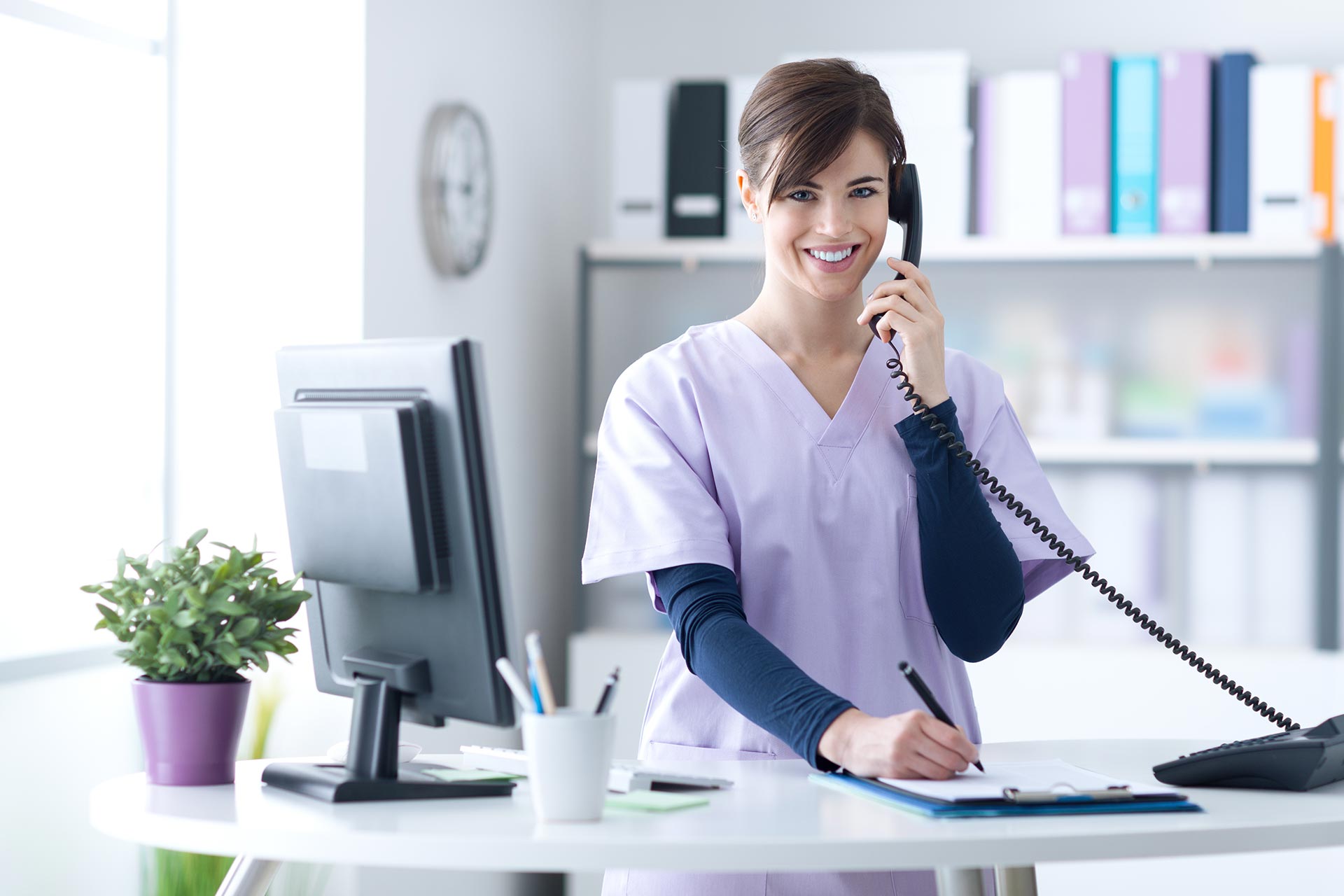 Smiling Woman Behind Desk On The Phone